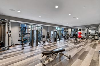 A gym with a variety of equipment including treadmills, weights, and exercise machines.